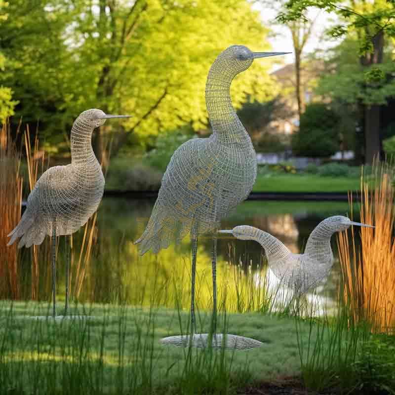 Abstract metal wire bird family art sculpture by the lake