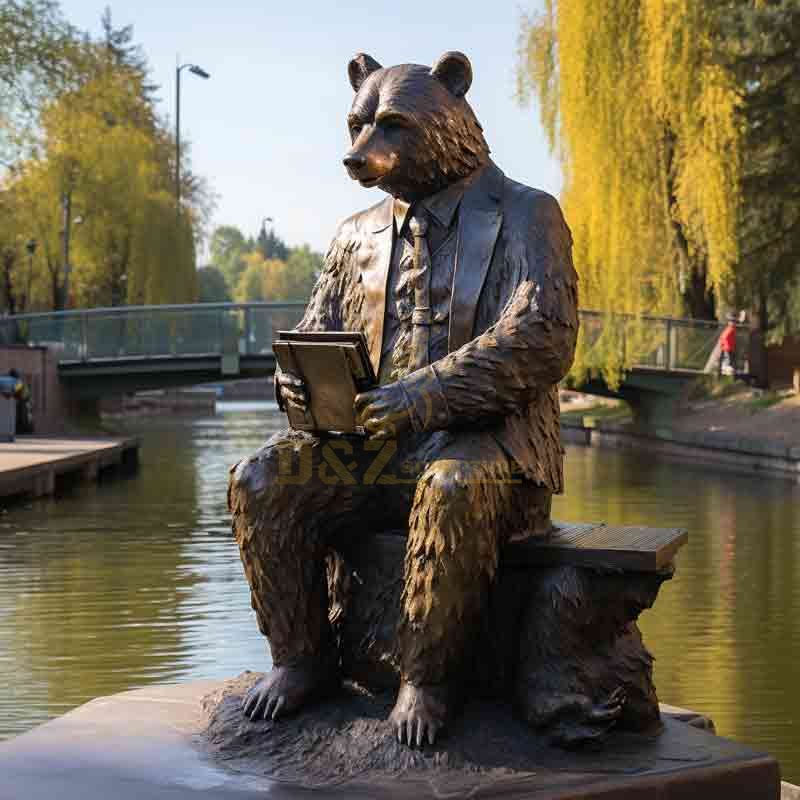 Bronze bear statue - Mr. Bear reading a book by the river